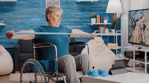 lady stretching in wheelchair with resistance band