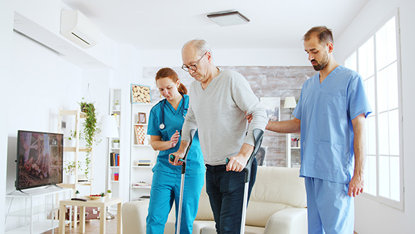 nurses helping patient walk